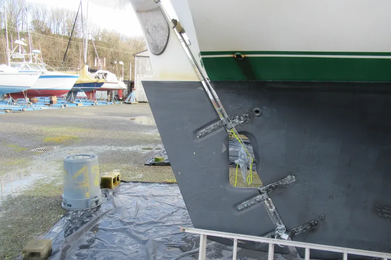 Slide: The Image of 1979 Cape George 36 sailboat hull in dry dock, showing rudder and propeller aperture. - 44