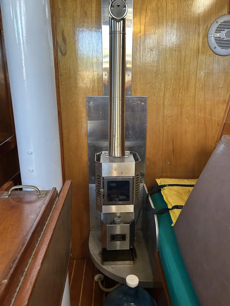 Slide: The Image of Wood stove inside a 1979 Cape George 36 sailboat cabin with wooden interior. - 6