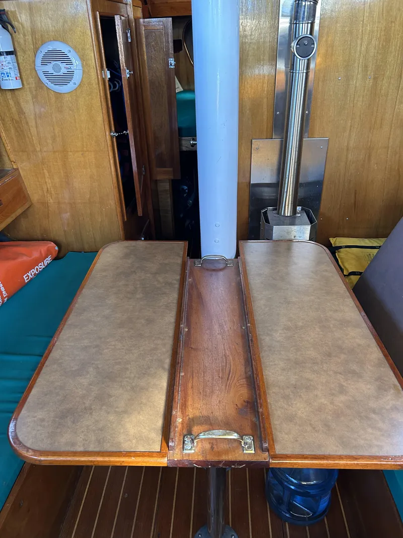 Slide: The Image of Interior of a 1979 Cape George 36 sailboat with a wooden foldable table. - 7