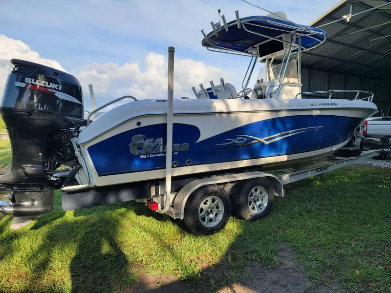 Slide: The Image of 2012 Carolina Skiff 24 boat with Suzuki engine on trailer, parked outdoors. - 1