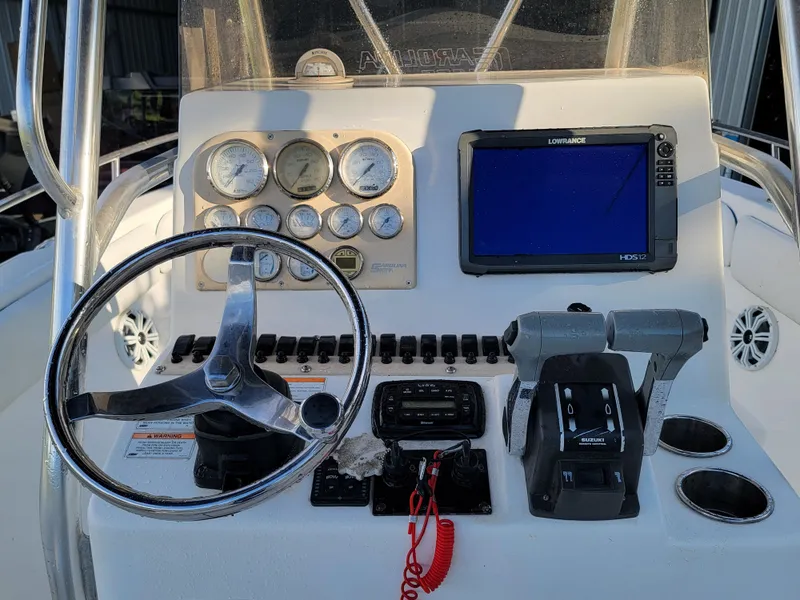 Slide: The Image of Control panel of a 2012 Carolina Skiff 24 boat with steering wheel and navigation system. - 4