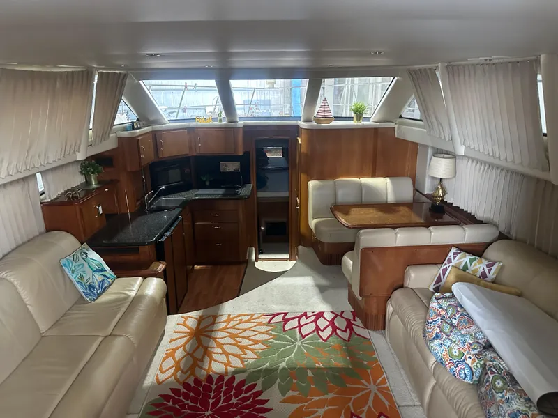 Slide: The Image of Luxurious 2005 Carver 44 CMY yacht interior with elegant seating, vibrant rug, and modern kitchen. - 3