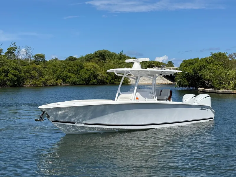 Slide: The Image of 2023 Jupiter 30 boat on calm water, surrounded by lush greenery. - 3