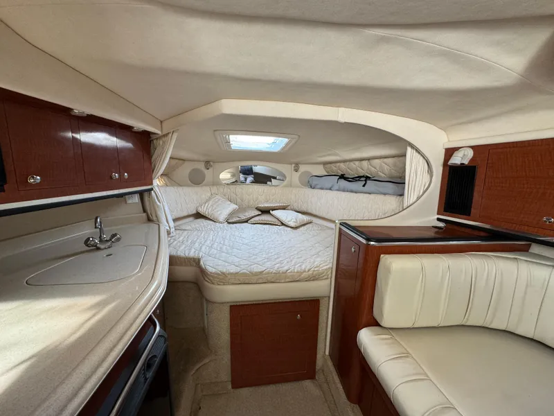 Slide: The Image of 2003 Sea Ray 290 Amberjack cabin interior with bed, kitchenette, and seating area. - 10