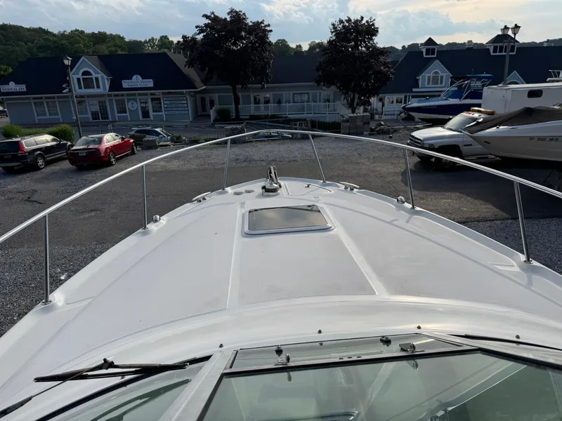 Slide: The Image of 2003 Sea Ray 290 Amberjack boat docked near buildings and parked cars. - 16