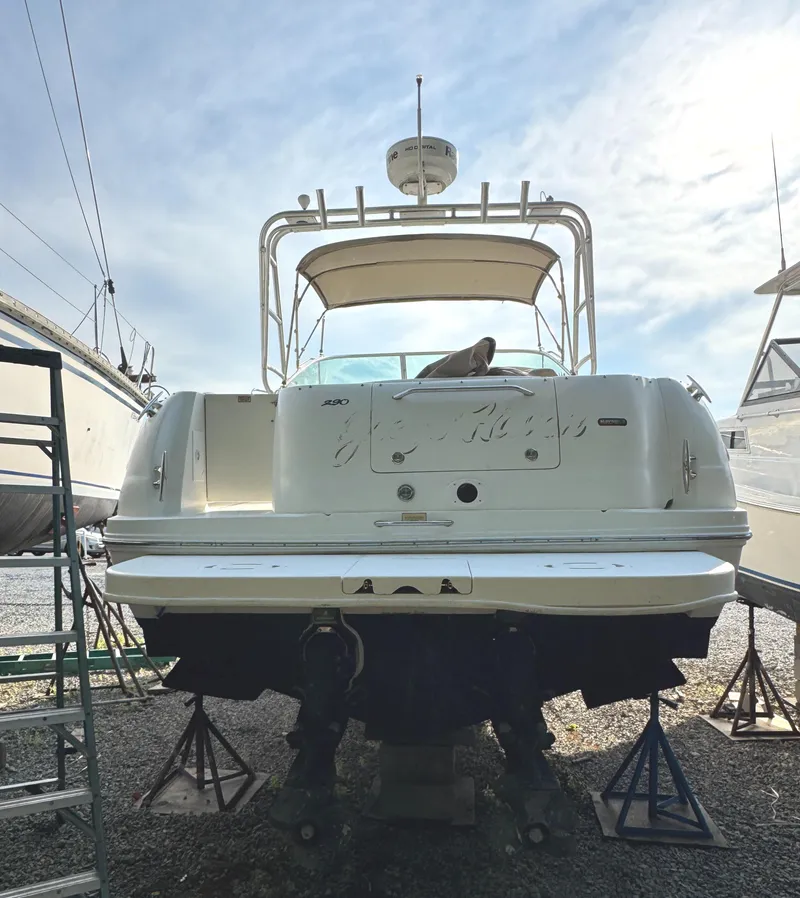 Slide: The Image of 2003 Sea Ray 290 Amberjack boat on stands, rear view, under a clear sky. - 2