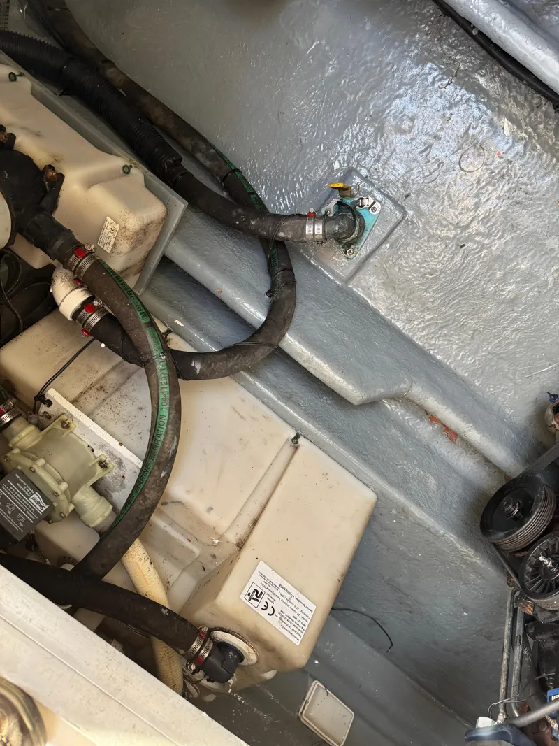 Slide: The Image of Engine compartment of a 2003 Sea Ray 290 Amberjack boat, showing hoses and components. - 21