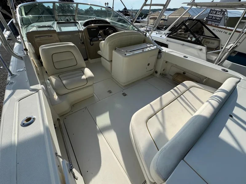 Slide: The Image of 2003 Sea Ray 290 Amberjack boat interior with seating and helm, docked in marina. - 3
