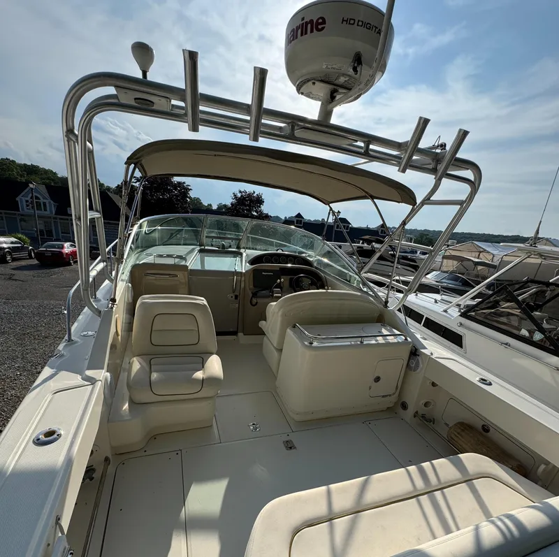 Slide: The Image of 2003 Sea Ray 290 Amberjack boat interior with seating and steering wheel, docked at marina. - 5