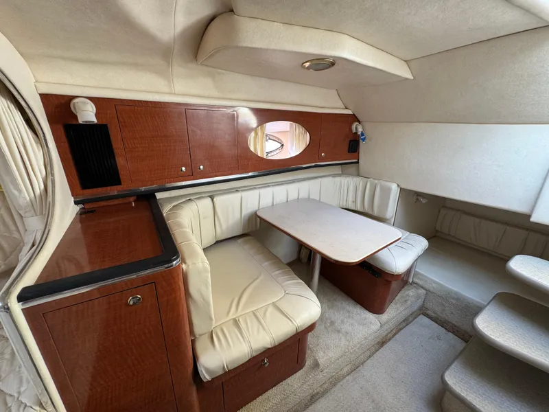 Slide: The Image of 2003 Sea Ray 290 Amberjack cabin interior with seating and table. - 9