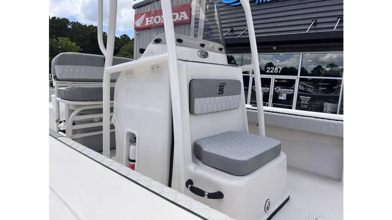 Slide: The Image of 2025 Carolina Skiff 24 Ultra Elite boat interior with seating and console, displayed outdoors. - 10
