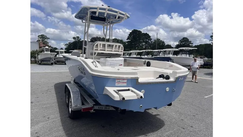 Slide: The Image of 2025 Carolina Skiff 24 Ultra Elite boat on trailer, parked outdoors under a cloudy sky. - 4