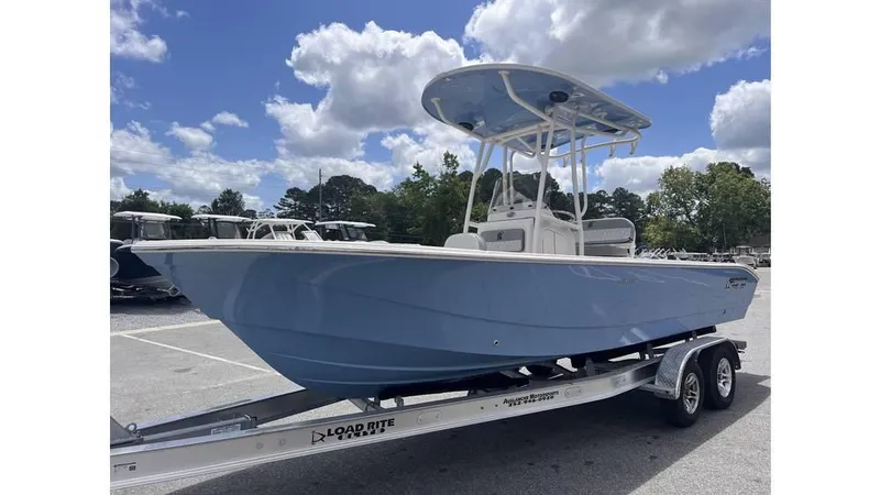 Slide: The Image of 2025 Carolina Skiff 24 Ultra Elite boat on trailer under blue sky. - 5