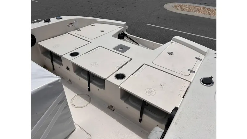 Slide: The Image of 2025 Carolina Skiff 24 Ultra Elite boat deck with storage compartments and cup holders. - 8