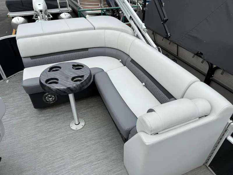 Slide: The Image of 2023 Godfrey Sweetwater boat interior with gray seating and round table. - 10