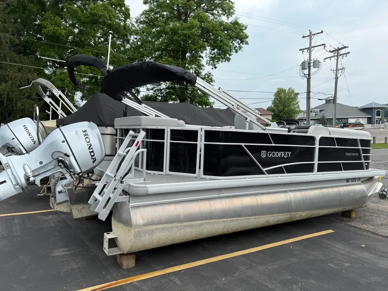 Slide: The Image of 2023 Godfrey Sweetwater pontoon boat with Honda engines, parked outdoors. - 3