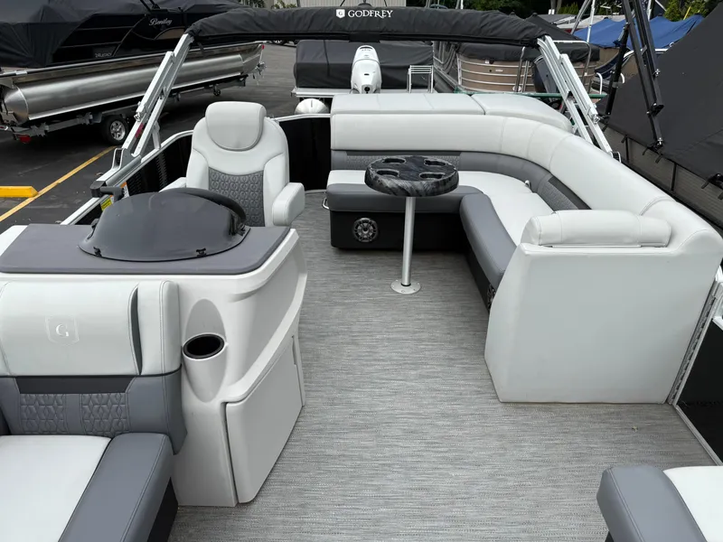 Slide: The Image of 2023 Godfrey Sweetwater pontoon boat interior with gray seating and table. - 8