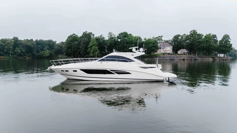 Slide: The Image of 2013 Sea Ray 510 Sundancer yacht on calm lake with wooded shoreline. - 10