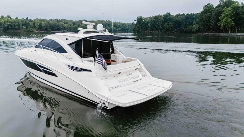 Slide: The Image of 2013 Sea Ray 510 Sundancer yacht cruising on a serene lake. - 18