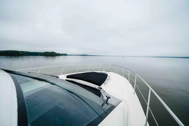 Slide: The Image of 2013 Sea Ray 510 Sundancer cruising on a calm lake under overcast skies. - 34