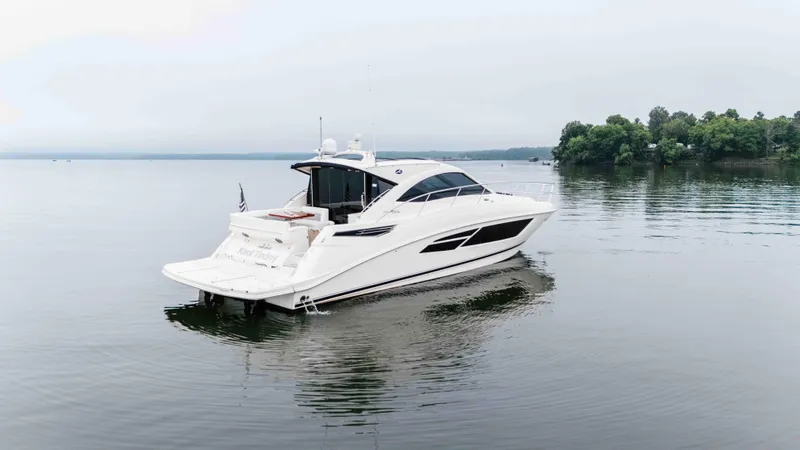 Slide: The Image of 2013 Sea Ray 510 Sundancer yacht on calm water, surrounded by trees. - 4