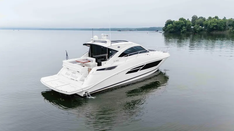 Slide: The Image of 2013 Sea Ray 510 Sundancer yacht on calm water, surrounded by trees. - 5