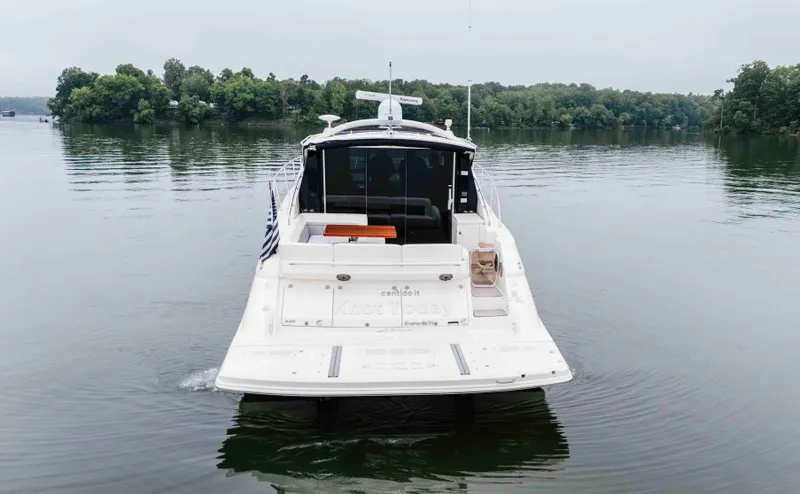 Slide: The Image of 2013 Sea Ray 510 Sundancer yacht on calm lake with lush green shoreline. - 7