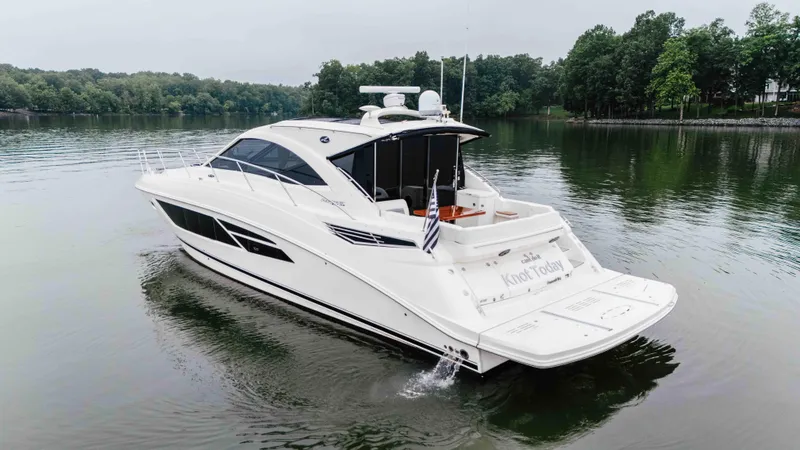 Slide: The Image of 2013 Sea Ray 510 Sundancer yacht cruising on a serene lake with lush green surroundings. - 8