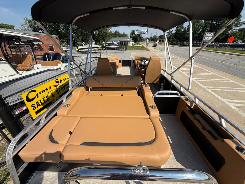 Slide: The Image of 2025 Avalon Venture 85 Versatile rear bench boat with tan seating, displayed at a sales lot. - 34