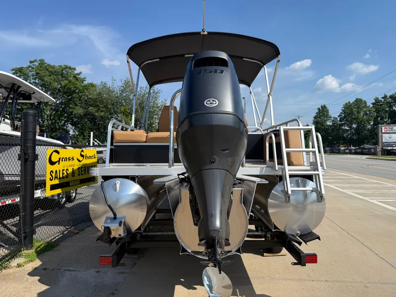 Slide: The Image of 2025 Avalon Venture 85 Versatile rear Bench pontoon boat with outboard motor, parked outdoors. - 5