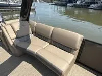 Slide: The Image of 2022 Bennington 30 RSRAX2 boat with beige seating, docked by the water. - 15