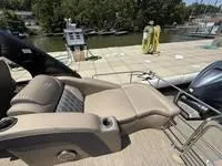 Slide: The Image of 2022 Bennington 30 RSRAX2 boat with luxurious seating, docked by a scenic waterfront. - 27