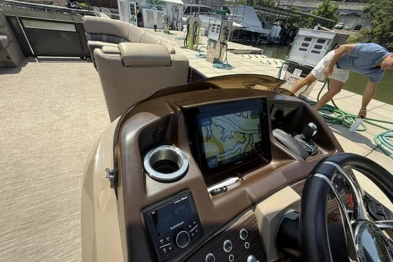 Slide: The Image of 2022 Bennington 30 RSRAX2 boat dashboard with navigation screen and controls at dock. - 36