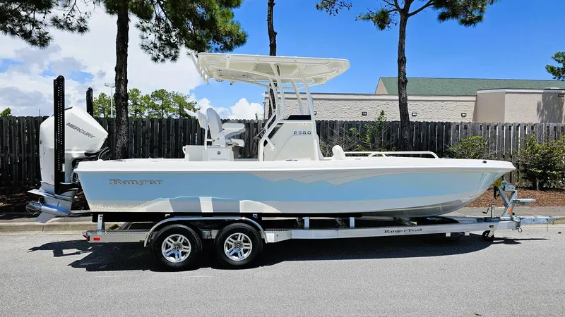Slide: The Image of 2025 Ranger 2360 Bay boat on trailer, parked outdoors, side view. - 0