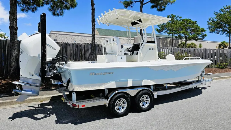 Slide: The Image of 2025 Ranger 2360 Bay boat on trailer, parked outdoors, featuring Mercury engine. - 1