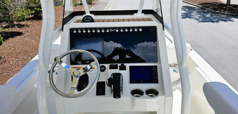 Slide: The Image of 2025 Ranger 2360 Bay boat dashboard with steering wheel and navigation controls. - 13