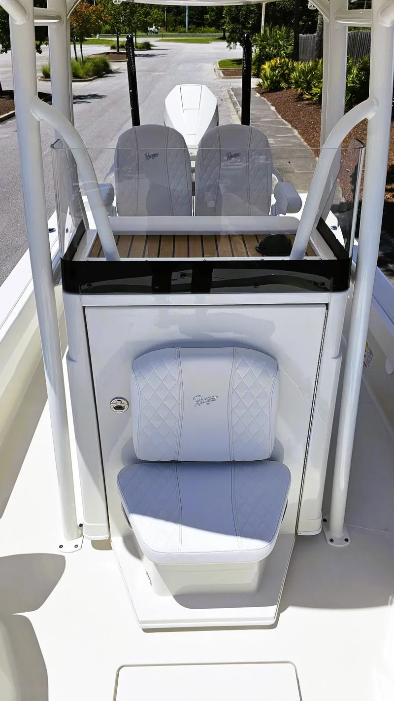 Slide: The Image of 2025 Ranger 2360 Bay boat interior with white seating and console, outdoor setting. - 17