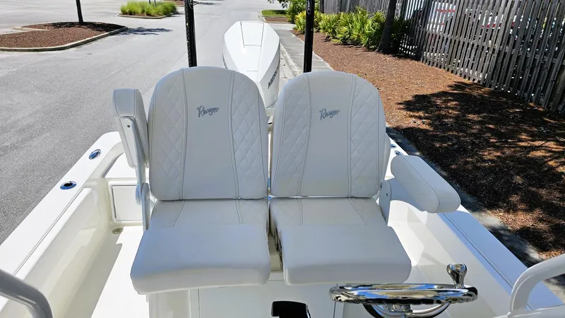 Slide: The Image of 2025 Ranger 2360 Bay boat with white cushioned seats and steering wheel. - 18