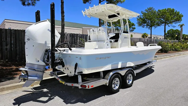 Slide: The Image of 2025 Ranger 2360 Bay boat on trailer, featuring a powerful outboard motor. - 3