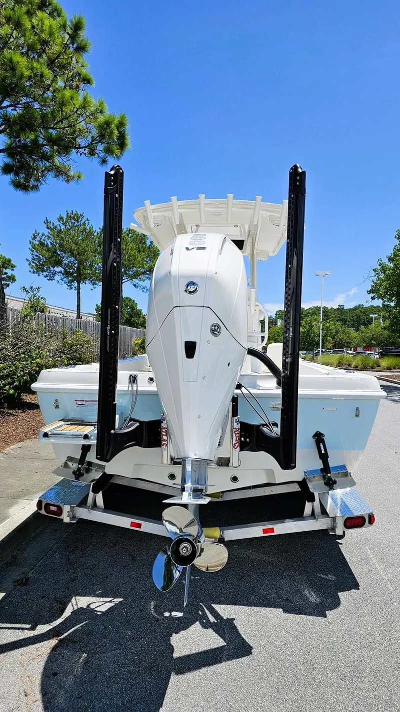 Slide: The Image of 2025 Ranger 2360 Bay boat on trailer, rear view, under clear blue sky. - 4