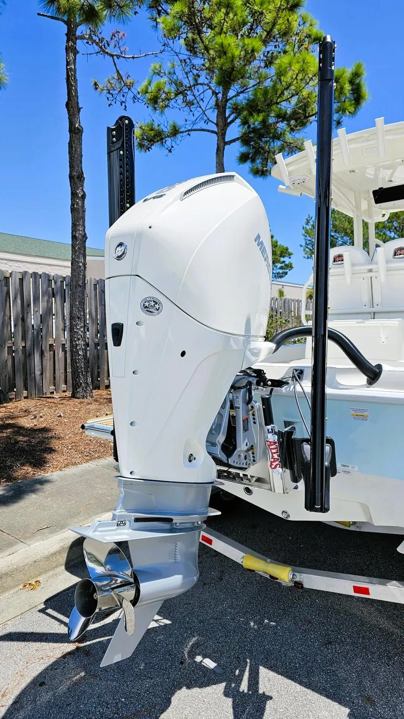 Slide: The Image of 2025 Ranger 2360 Bay boat with powerful outboard motor, parked outdoors on a sunny day. - 5