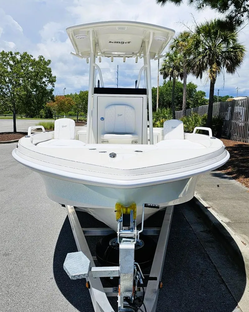 Slide: The Image of 2025 Ranger 2360 Bay boat on trailer, parked on a sunny street with palm trees. - 7
