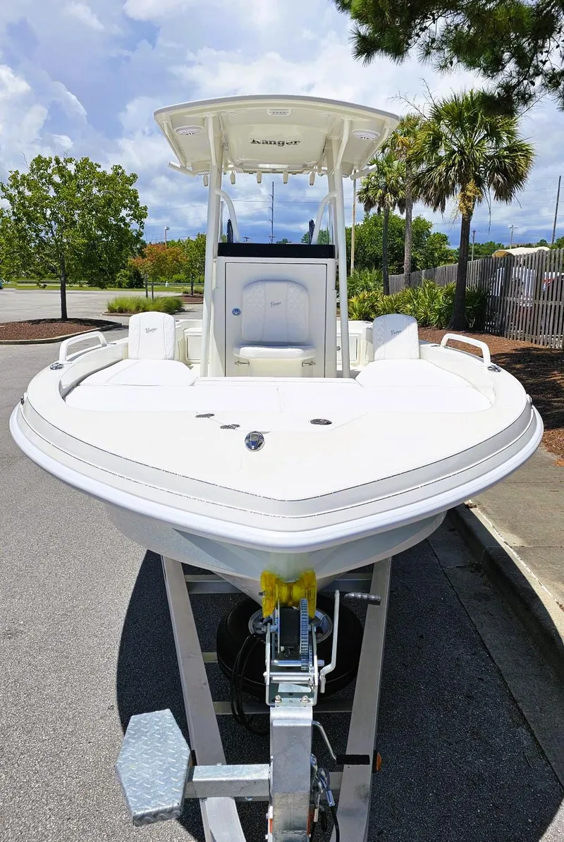 Slide: The Image of 2025 Ranger 2360 Bay boat on trailer, parked outdoors under a cloudy sky. - 8