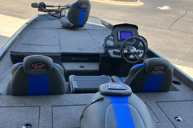 Slide: The Image of 2025 Ranger RT188P boat interior with steering console and seating, featuring blue and gray accents. - 2