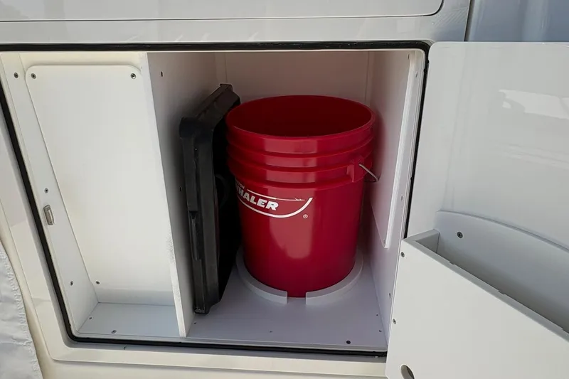 Slide: The Image of Storage compartment with red Boston Whaler bucket on 2025 Boston Whaler 365 Conquest boat. - 3