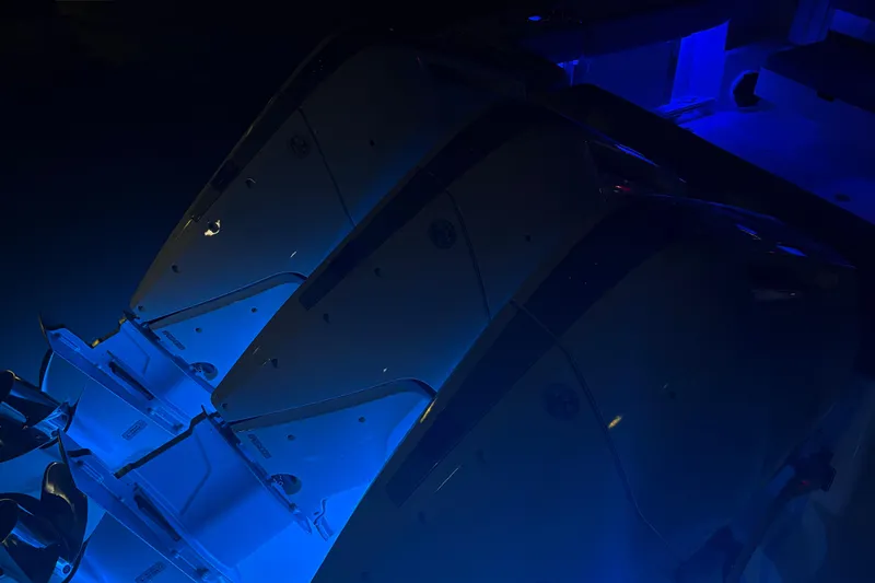 Slide: The Image of 2025 Boston Whaler 365 Conquest boat engines illuminated by blue light. - 34