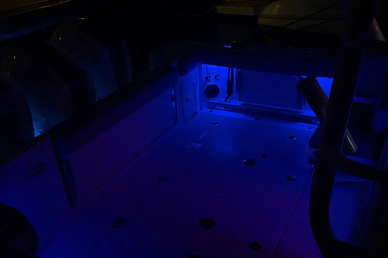 Slide: The Image of 2025 Boston Whaler 365 Conquest cockpit illuminated with blue LED lighting at night. - 35