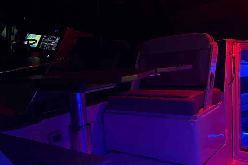 Slide: The Image of 2025 Boston Whaler 365 Conquest interior with illuminated seating and navigation controls. - 37