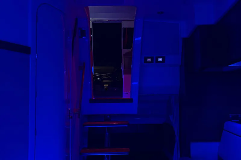 Slide: The Image of Interior of 2025 Boston Whaler 365 Conquest, illuminated in blue lighting. - 40