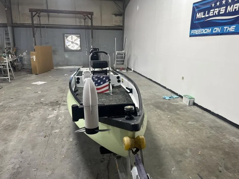 Slide: The Image of 2022 Gheenoe Low Tide 25 boat in a workshop, featuring an American flag. - 3